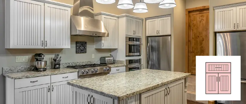 Kitchen with white beadboard cabinets and kitchen island with granite countertops.