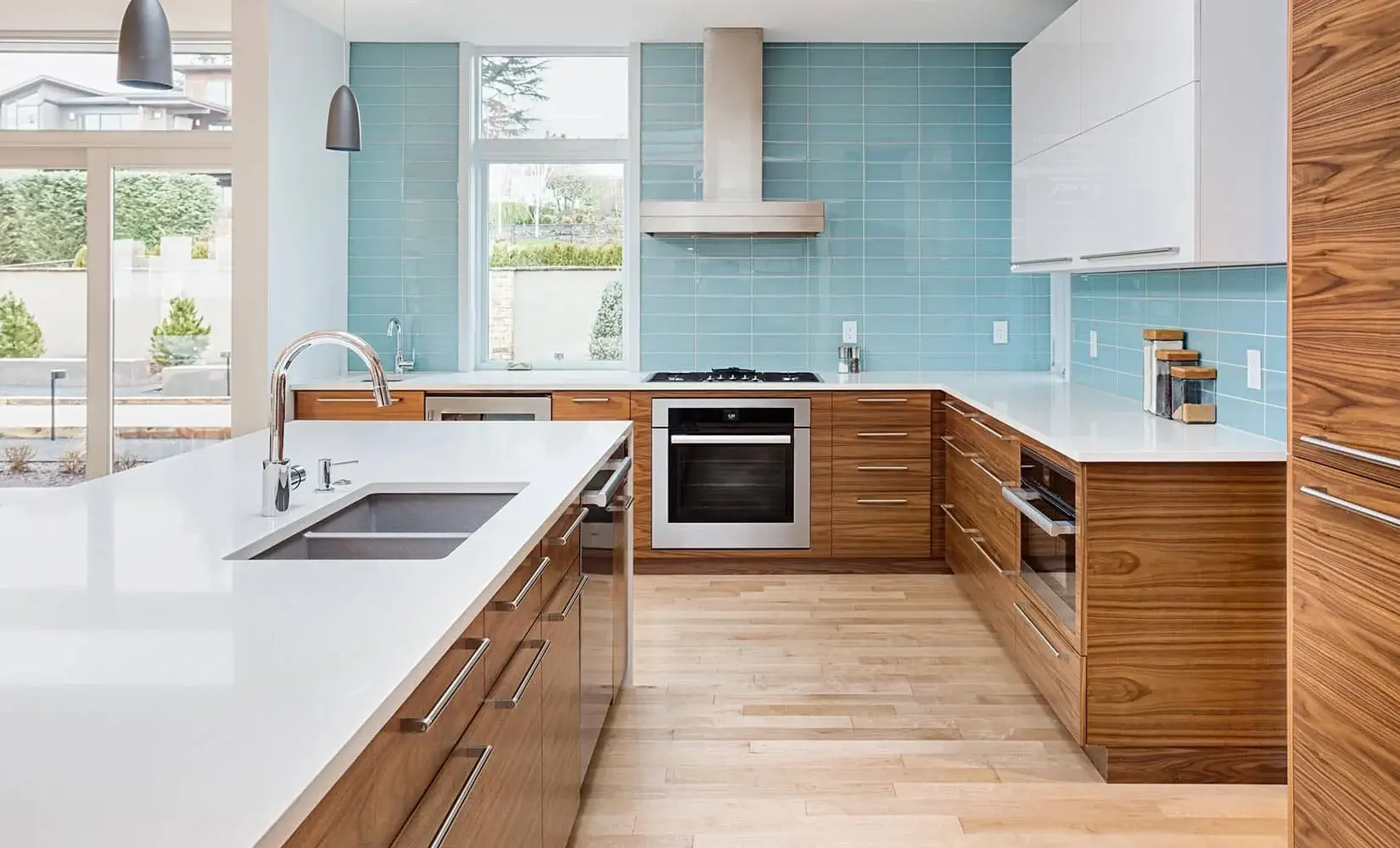 Kitchen with blue tile backsplash and faux wood melamine cabinets.