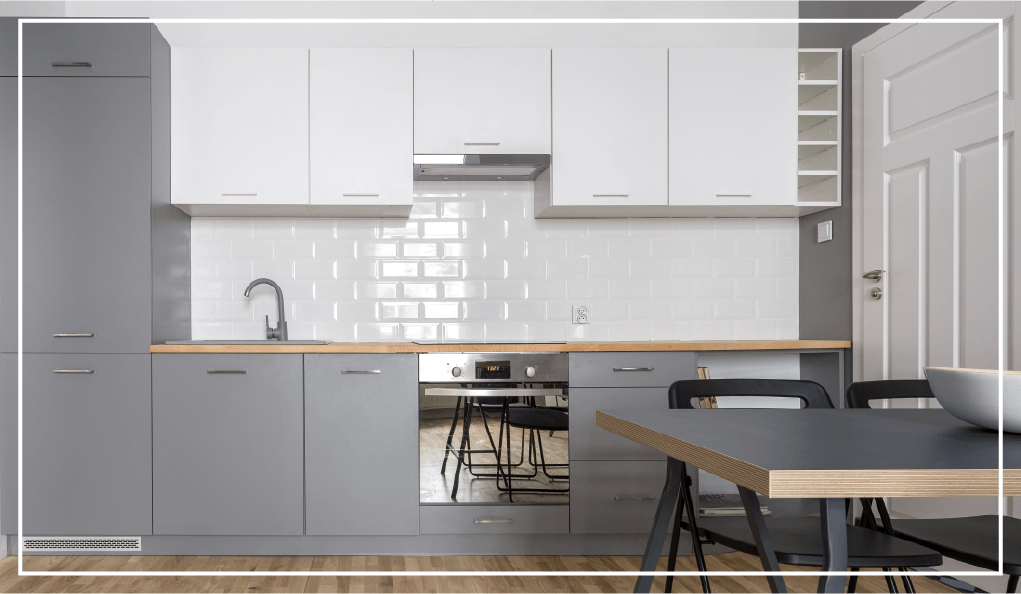 Two-toned cabinets in a bright kitchen with a white subway tile backsplash.