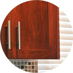 Dark glossy cherry wood cabinets with silver hardware.