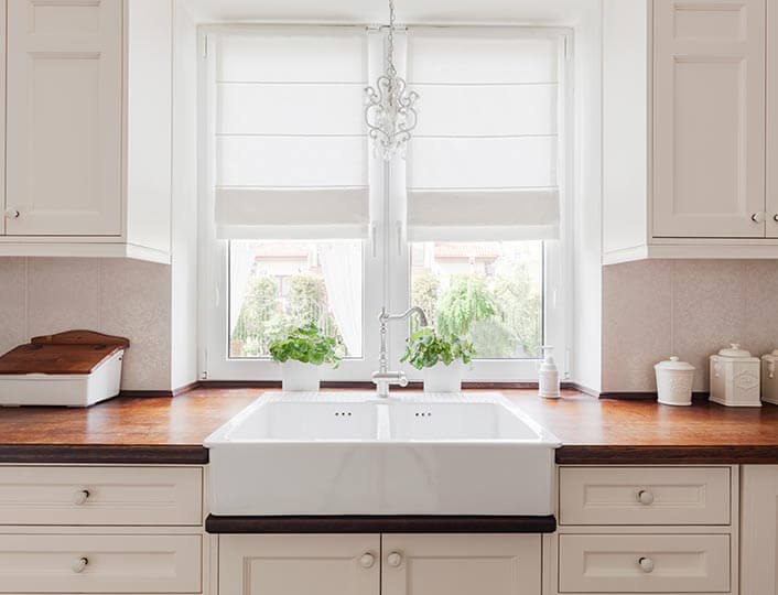White rustic kitchen with dark cherry wood countertops.