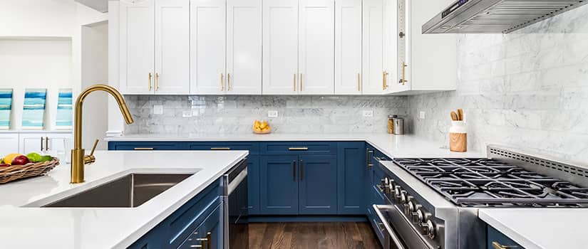 Modern kitchen with blue base cabinets and white upper cabinets.