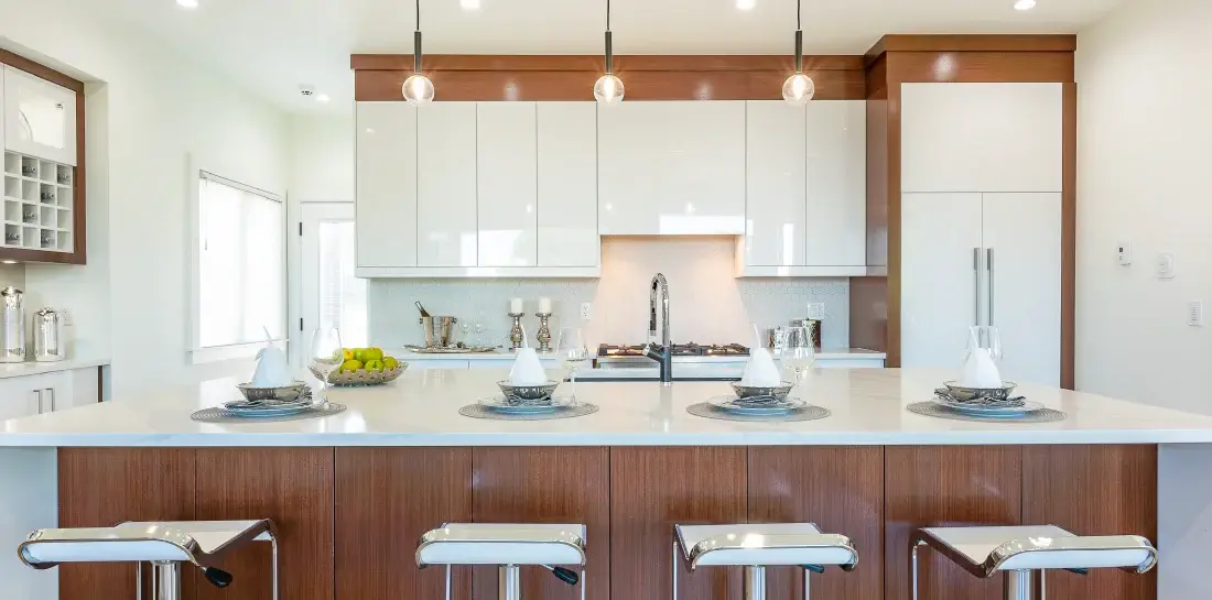 Modern coastal kitchen with sleek white and dark wood two-tone cabinets .