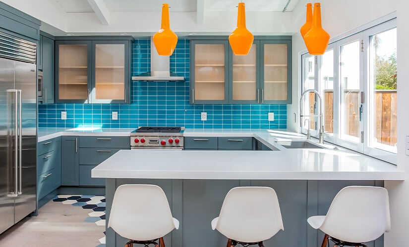Bright and colorful kitchen with orange pendant lights.