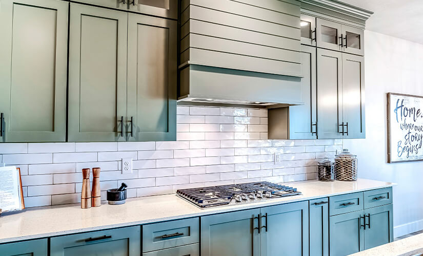 Image has textured tile backsplash with slotted design on oven hood as well.