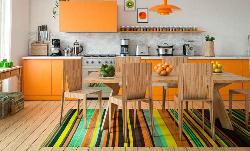 Image shows kitchen where shelves are painted bright orange for an accent.