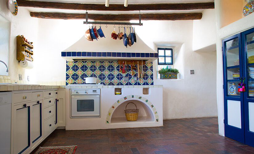 Image shows colorful southwestern kitchen working with original terracotta tile.