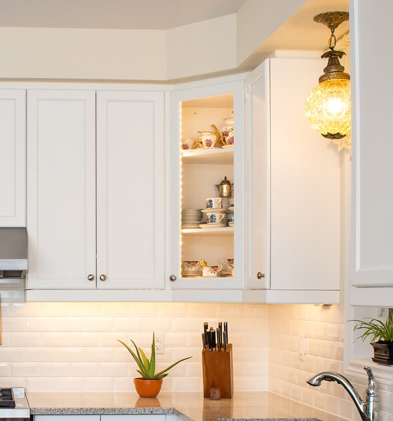 White glass corner display cabinets with silver hardware.