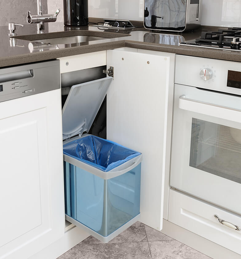 Blue hidden trash disposal inside white kitchen cabinet.