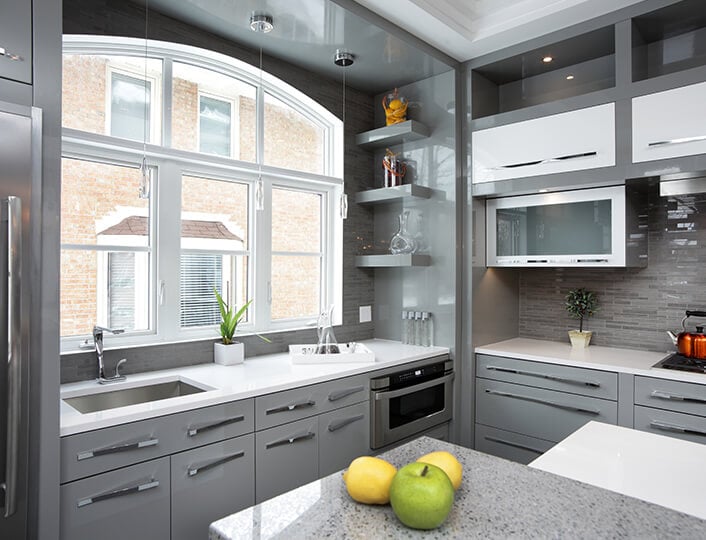 Sleek gray kitchen with corner shelves and a cornered oven.