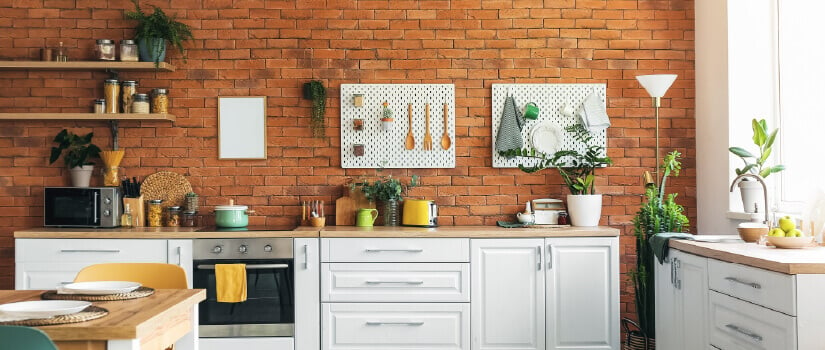 Kitchen with white cabinets, wood countertops, and brick backsplash.