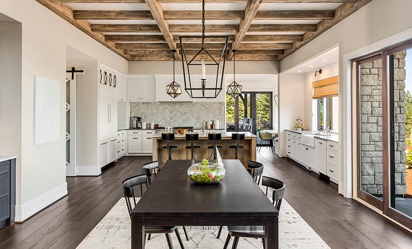  Craftsman kitchen and dining area with natural wood ceiling beams.