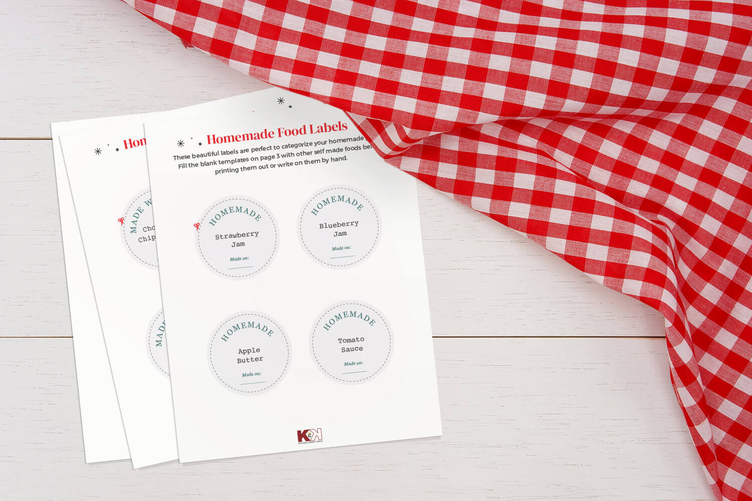Homemade food label templates on white wooden surface with red and white checkerboard tablecloth.