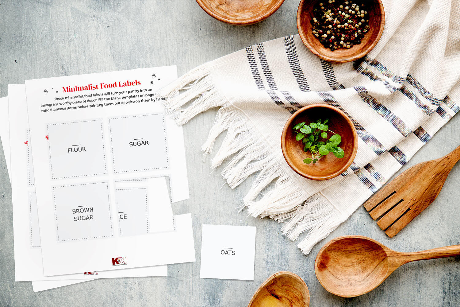 Minimalist food label templates on gray surface with white tablecloth and wooden kitchenware.