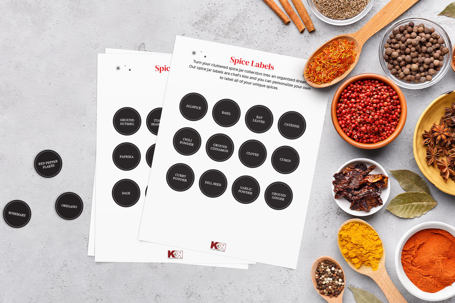 Black and white spice label templates on gray surface with different vibrant spices and herbs.