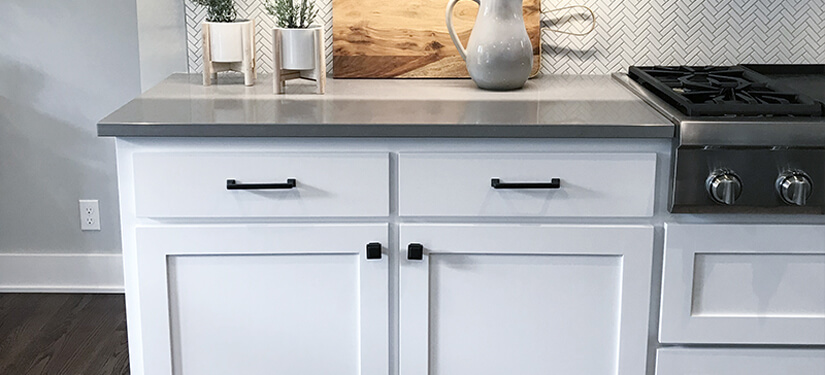 White framed base kitchen cabinets with black hardware.