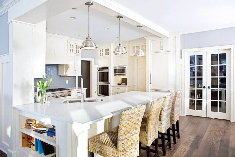 A g-shaped kitchen with white cabinets and countertops.