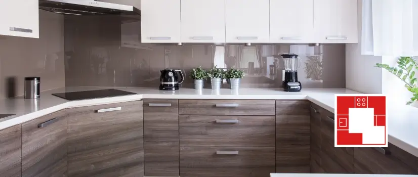 G-shaped kitchen with wood base cabinets and white countertops.