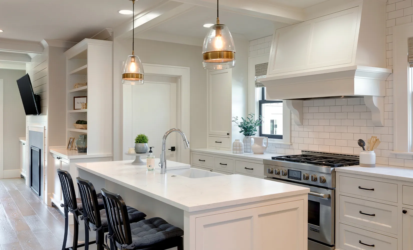 white galley kitchen with large glass pendant lights over island.