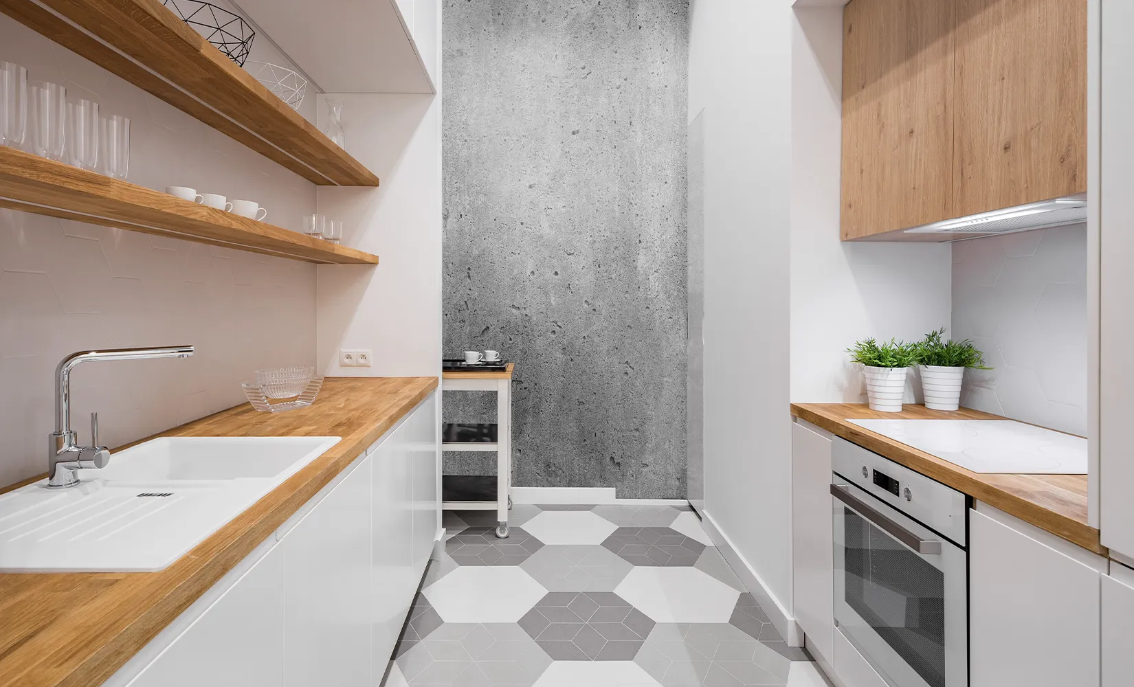 Galley kitchen with gray and white honeycomb floor tile.