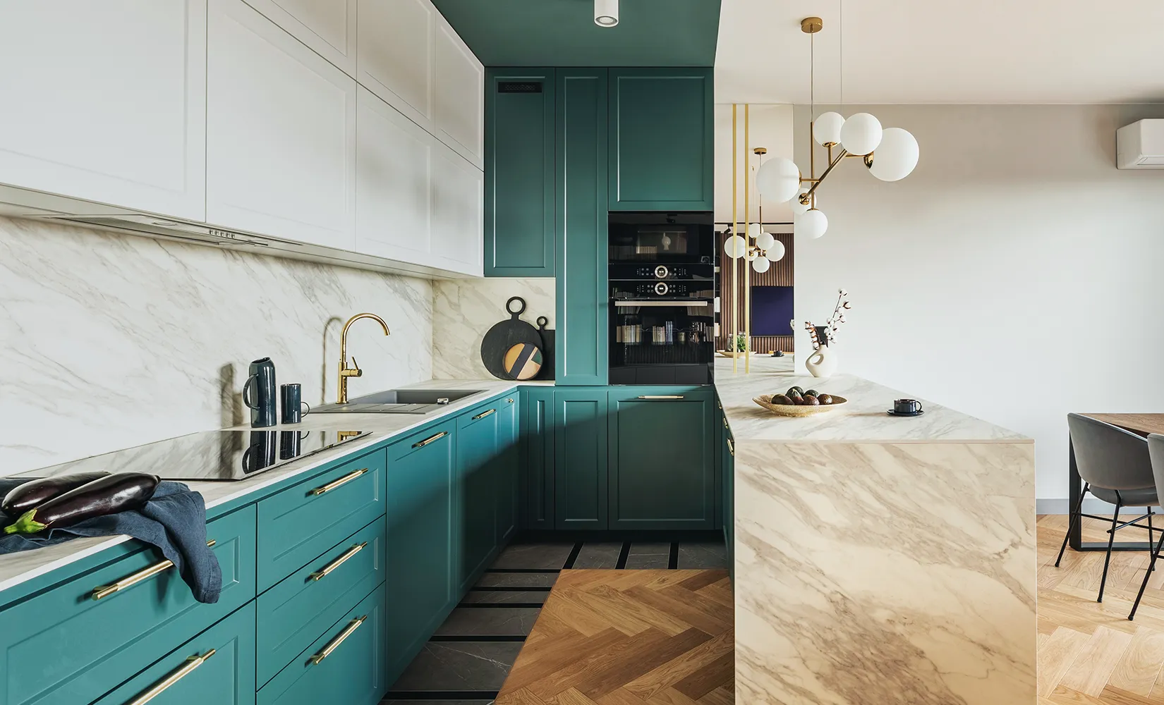 Galley kitchen with teal cabinets and vintage Mid-Century Modern pendant lights over island.