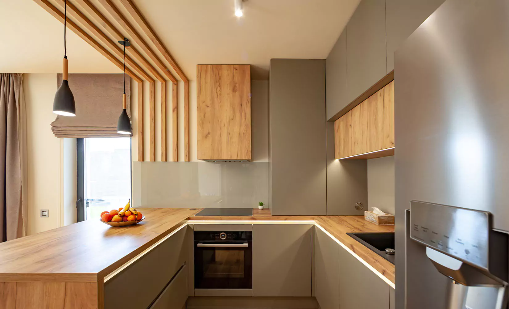 Gray kitchen with two tone gray and warm wood cabinets and countertops.