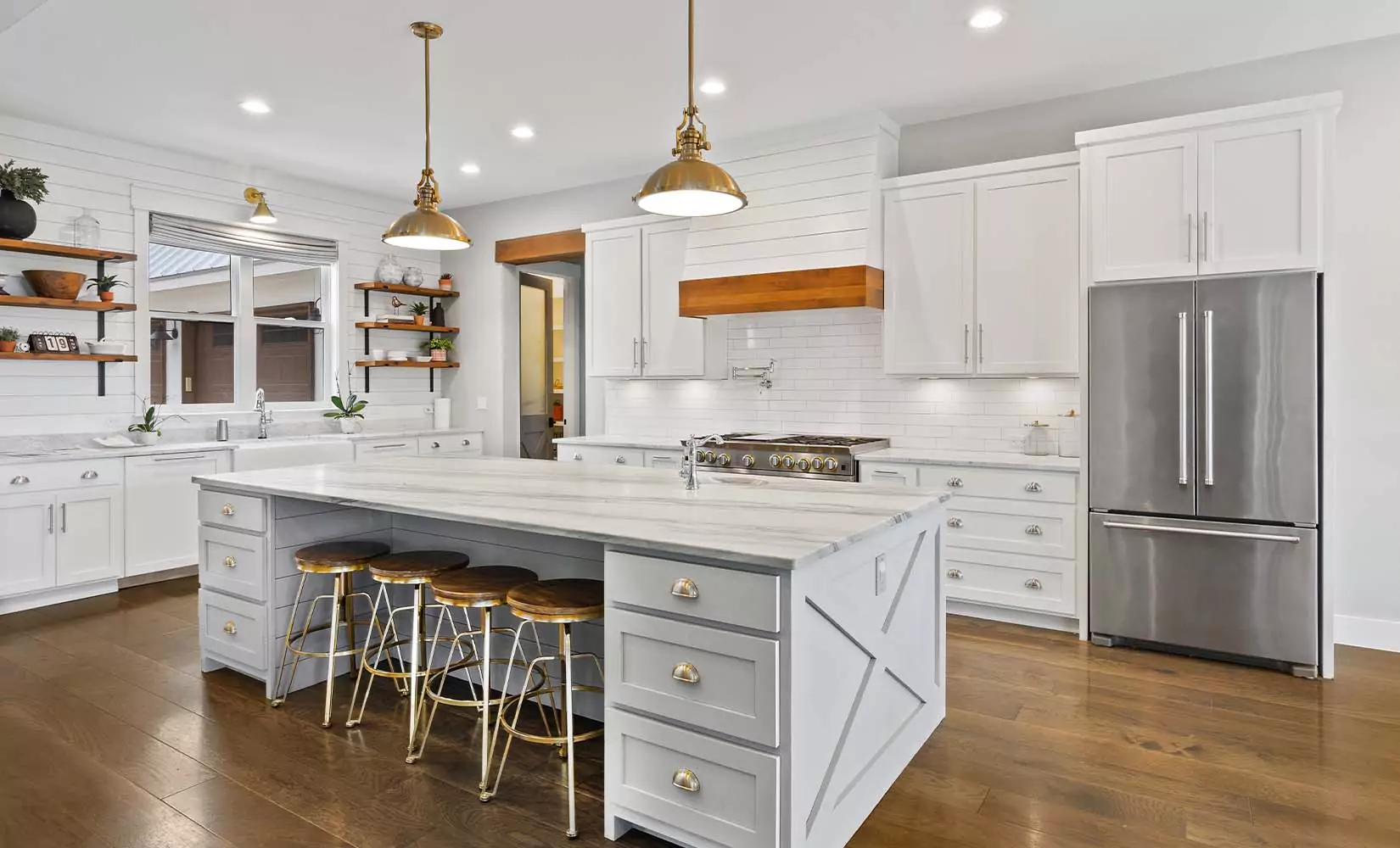 Gray farmhouse kitchen with antique bronze hardware and light fixtures.
