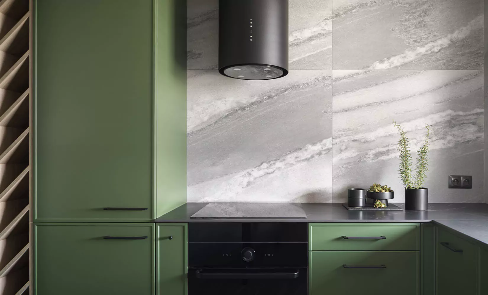 Gray kitchen with green cabinets and gray marble backsplash.