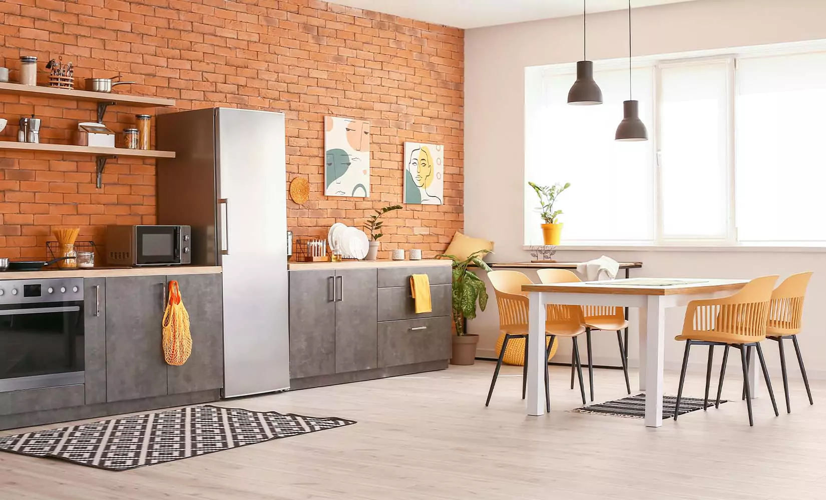 Urban kitchen with exposed brick backsplash and gray cabinets.