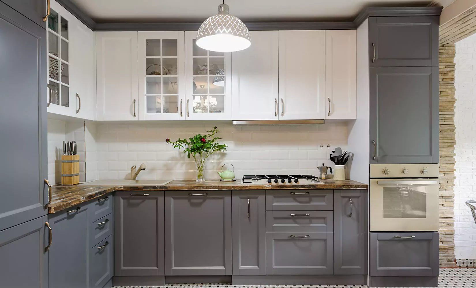 Transitional gray kitchen with gray and white shaker cabinets.