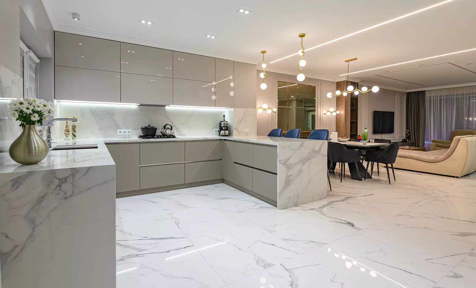 Modern kitchen with high gloss gray slab cabinets and marble countertops, floors, and backsplash.