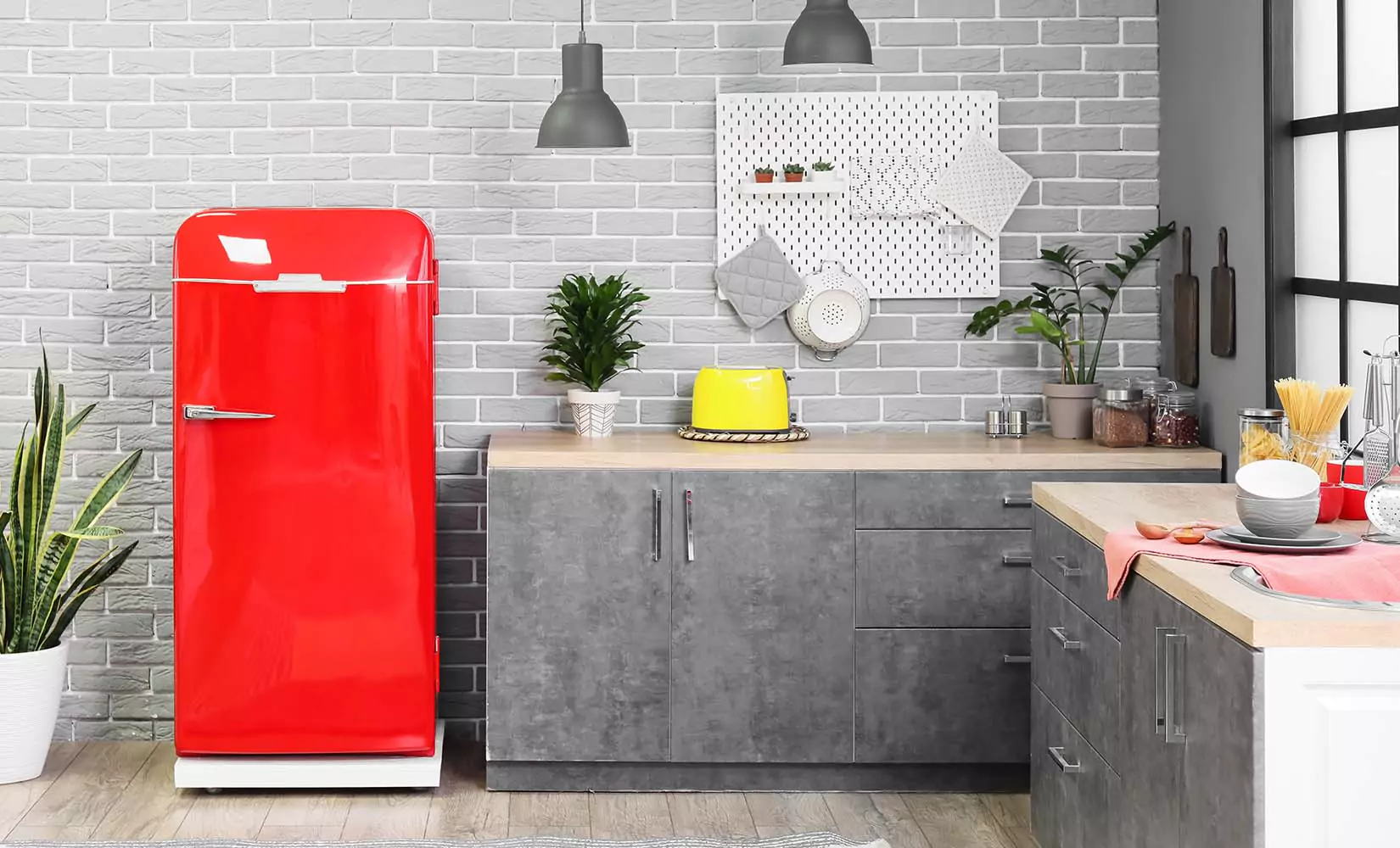 Gray kitchen with bright red refrigerator.