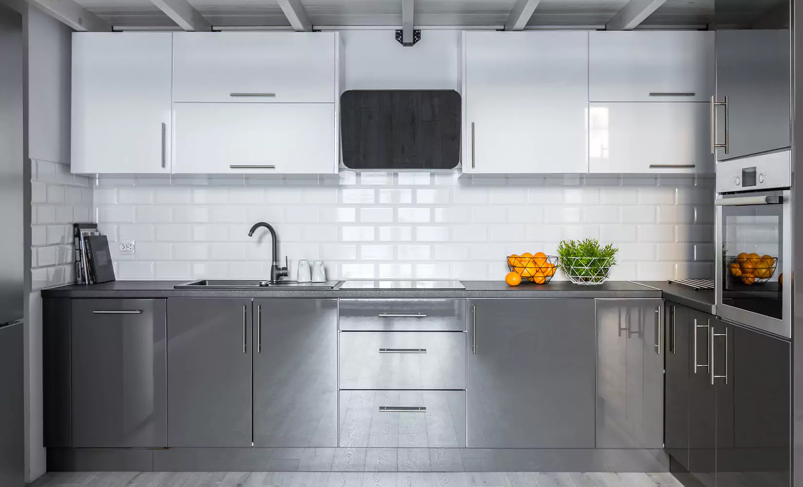 Kitchen with stainless steel cabinets and white subway tile backsplash.