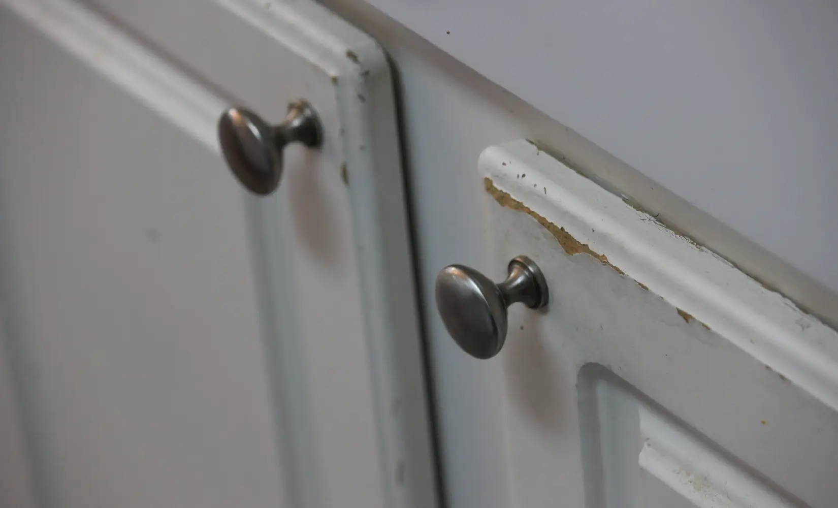 Older, damaged white cabinet doors.
