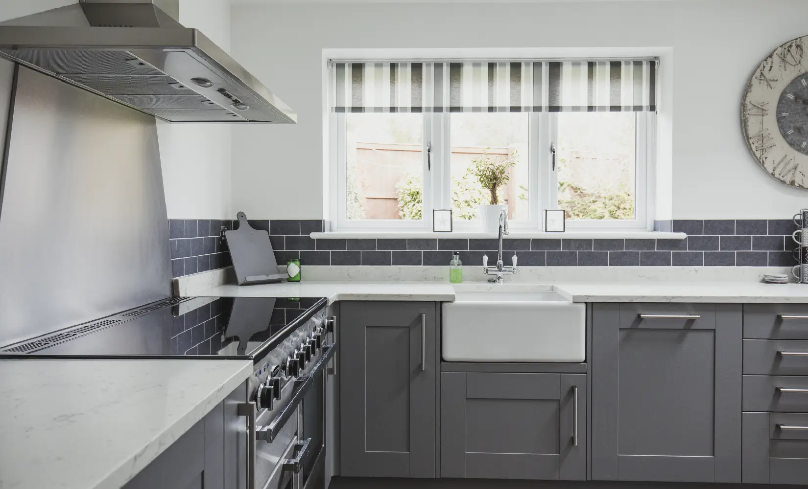 Nickel handles on gray shaker kitchen cabinets.