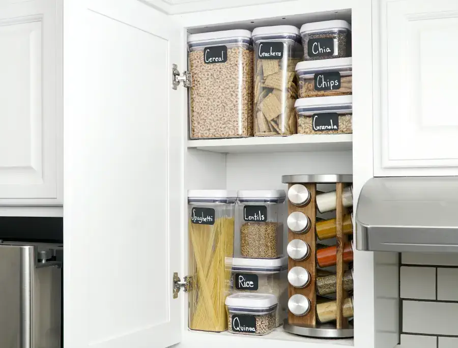 Labeled containers inside kitchen cabinets.