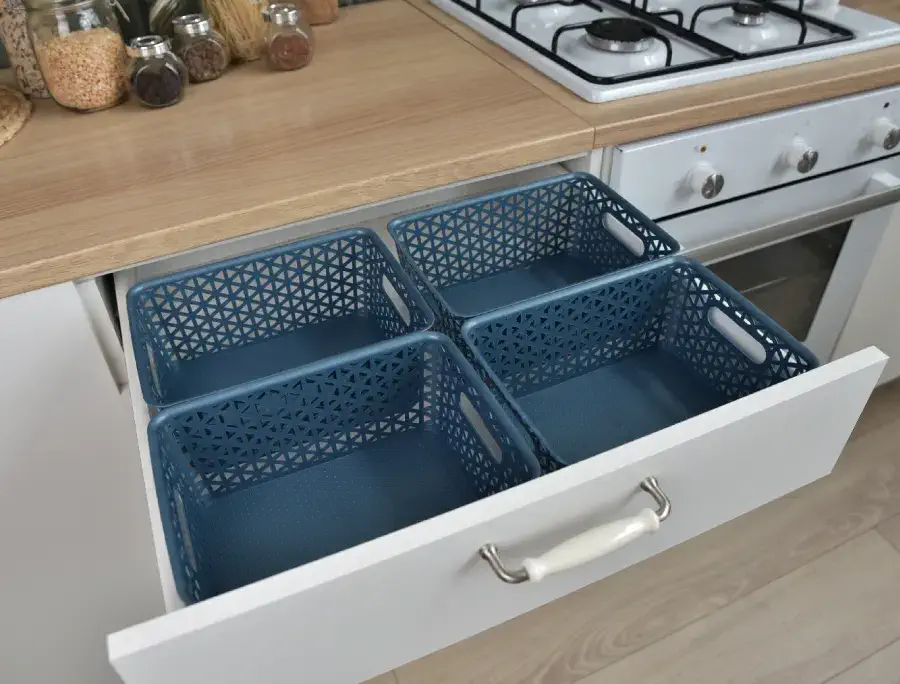 Bins and baskets inside a kitchen cabinet drawer.