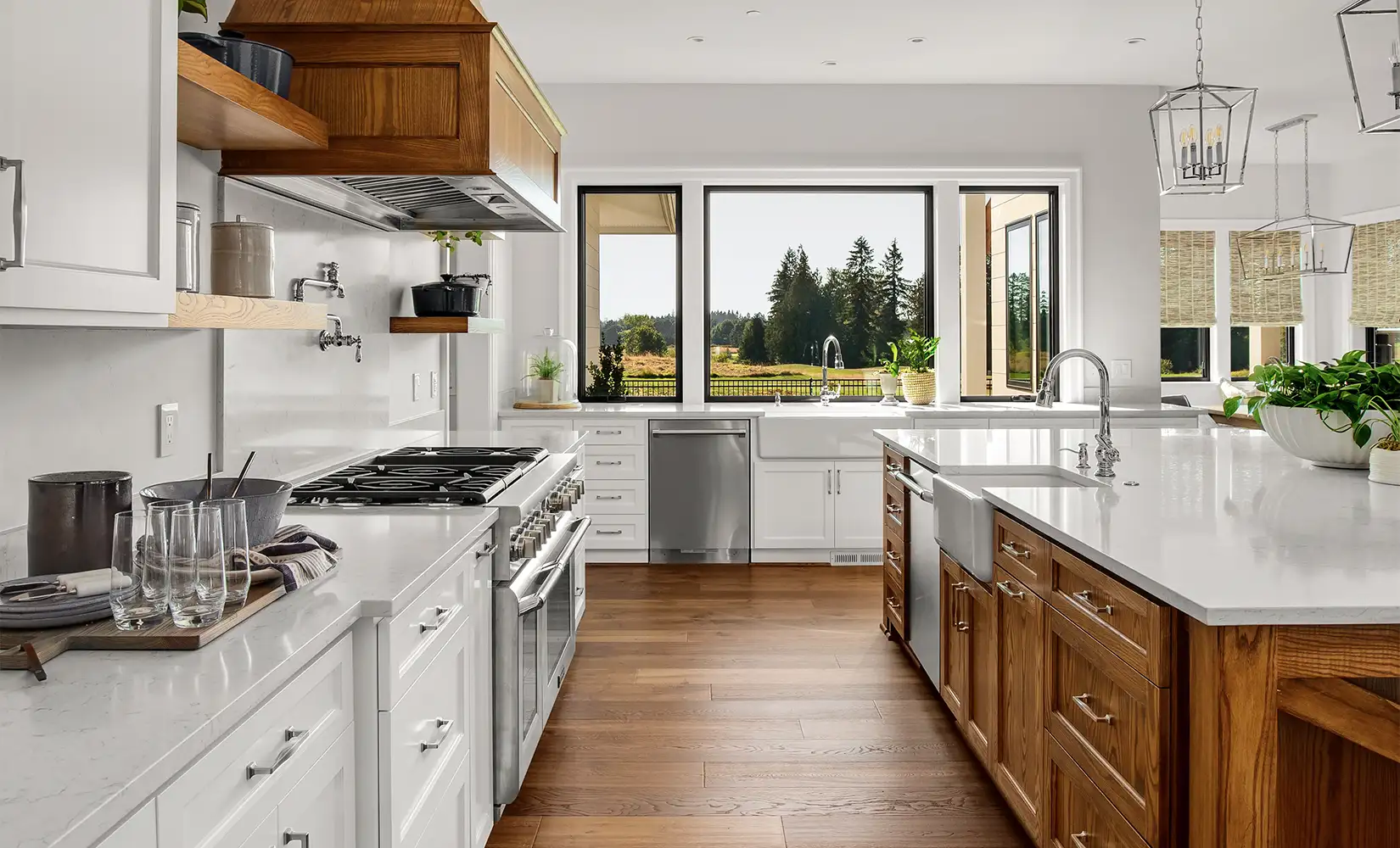 Industrial farmhouse kitchen with wood flooring, white cabinets, wood range hood over oven, and open window.