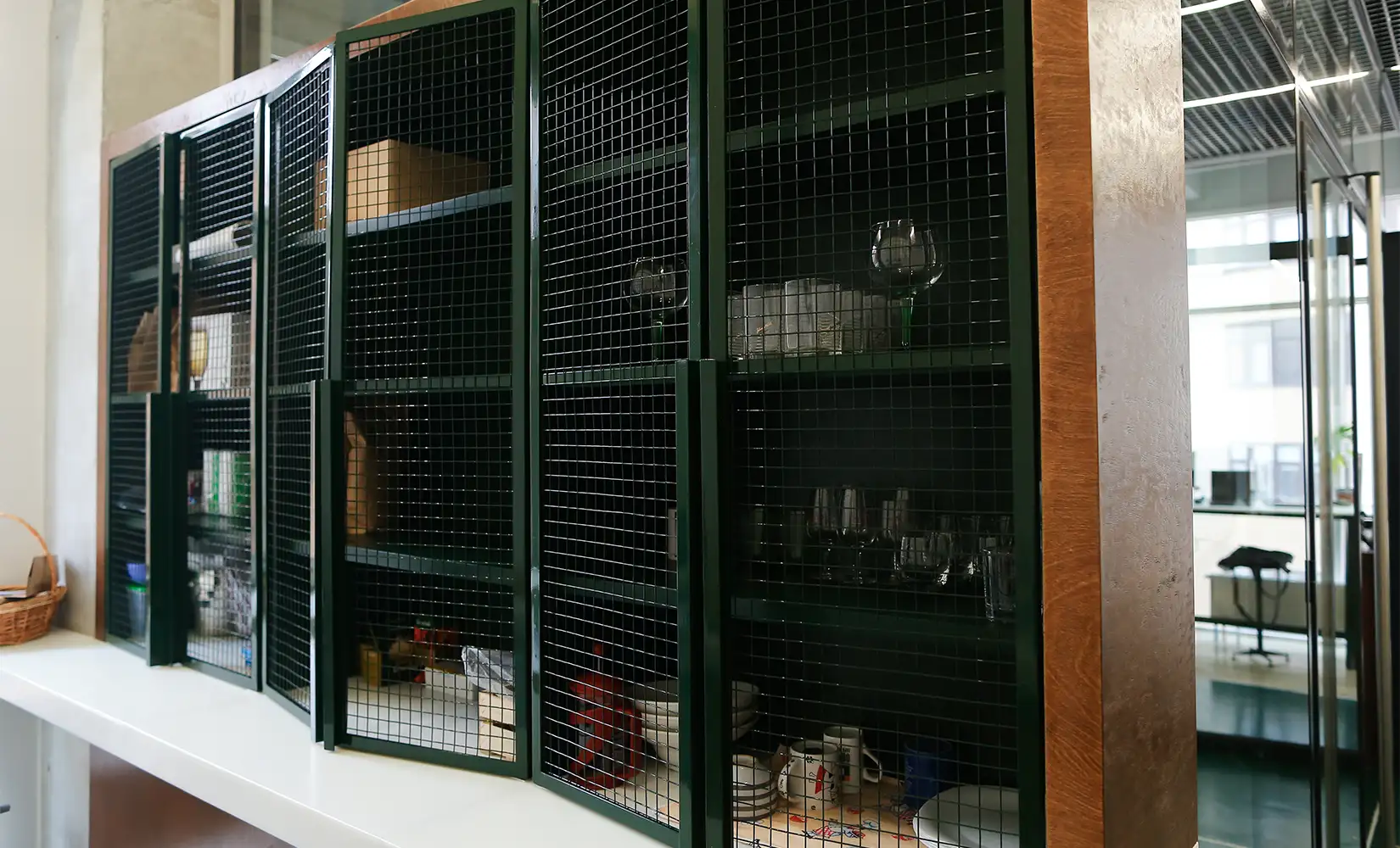 Green transparent metal grid kitchen cabinets.