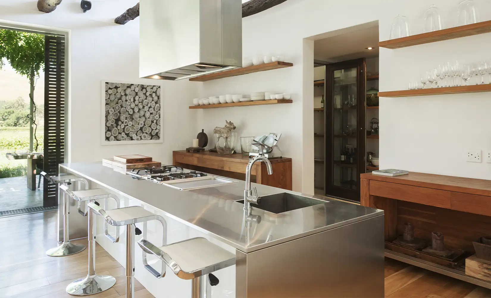 Modern kitchen with stainless steel countertop and silver faucet.