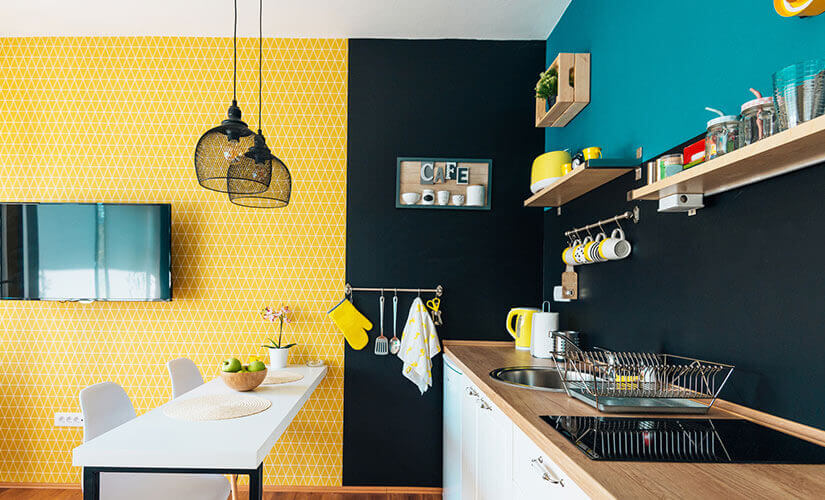 Yellow kitchen accent wall to the left of blue and black accent wall