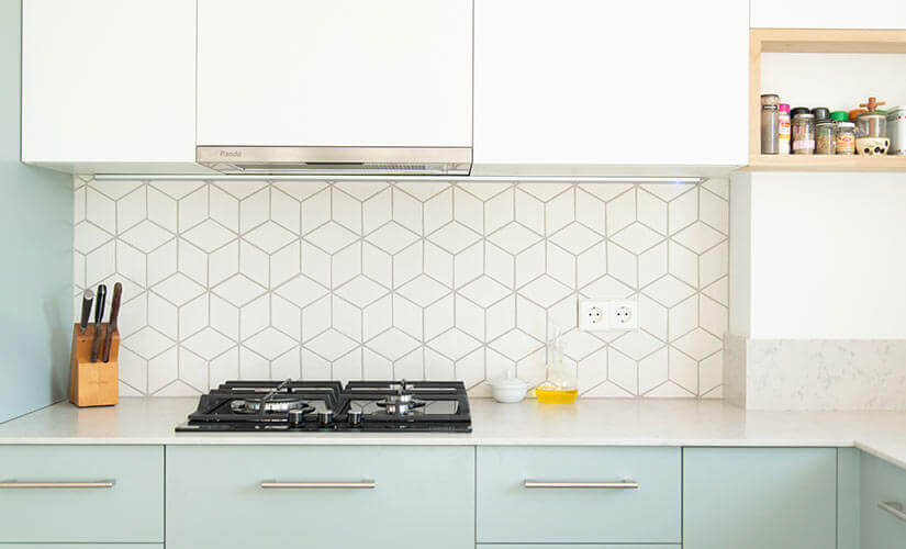 Kitchen with geometric tile backsplash behind stove