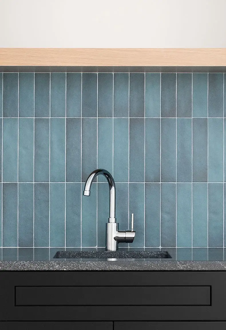 Blue kitchen backsplash with vertical tiles.