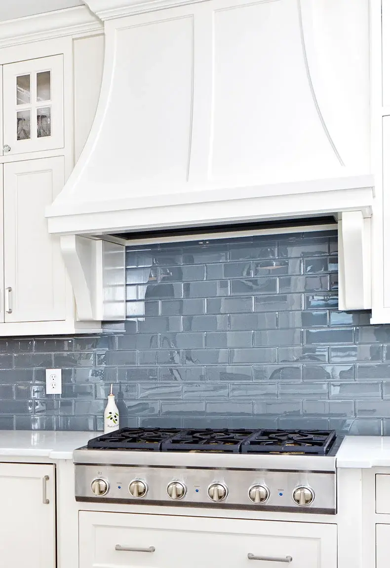 White kitchen with shiny gray kitchen backsplash tiles made from recycled glass.
