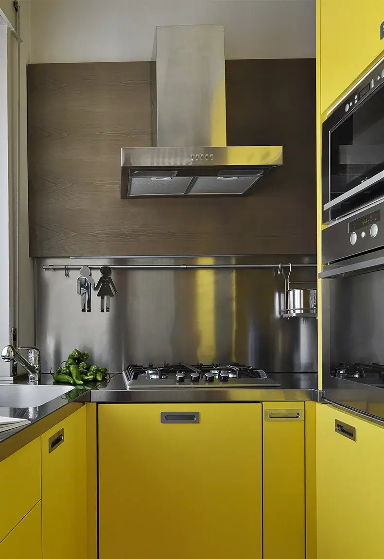 Modern all yellow kitchen with stainless steel kitchen backsplash.
