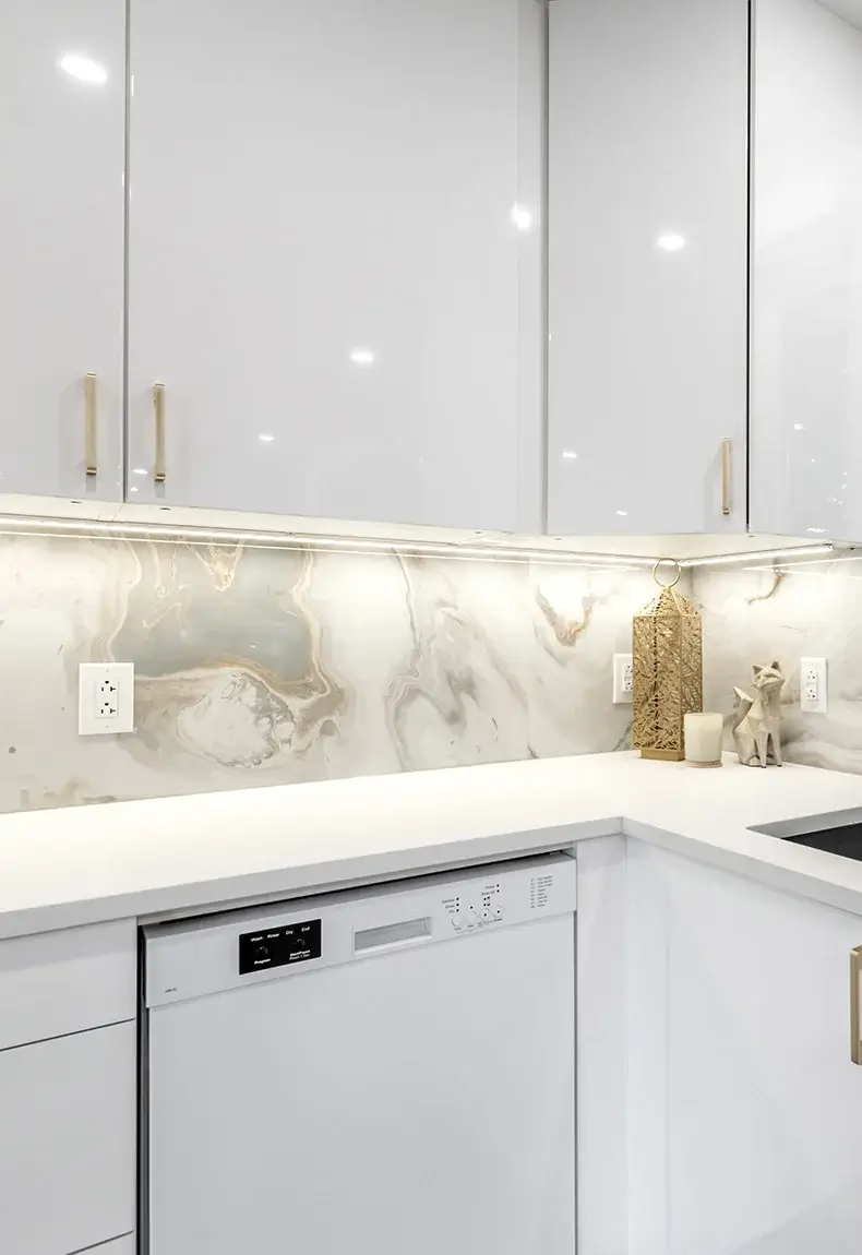 Elegant kitchen with white countertops, white cabinets, and an epoxy resin backsplash with a marble-like appearance.