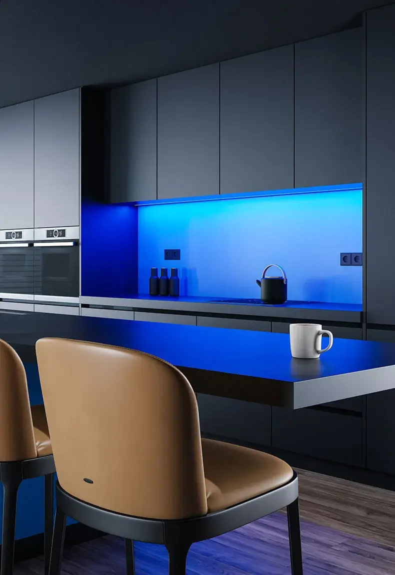 Gray cabinet kitchen with hardwood floors, tan chairs, and a kitchen island, illuminated by a vibrant blue neon backsplash.