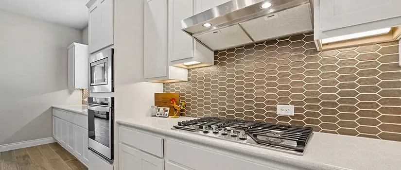 Modern kitchen with brown tile kitchen backsplash behind range.