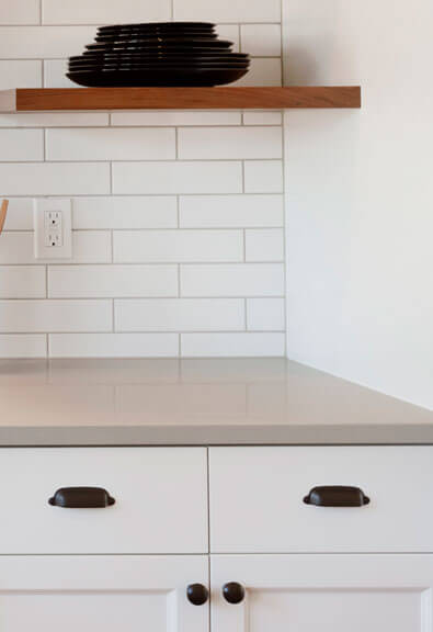 Black bin pulls on white kitchen drawers.