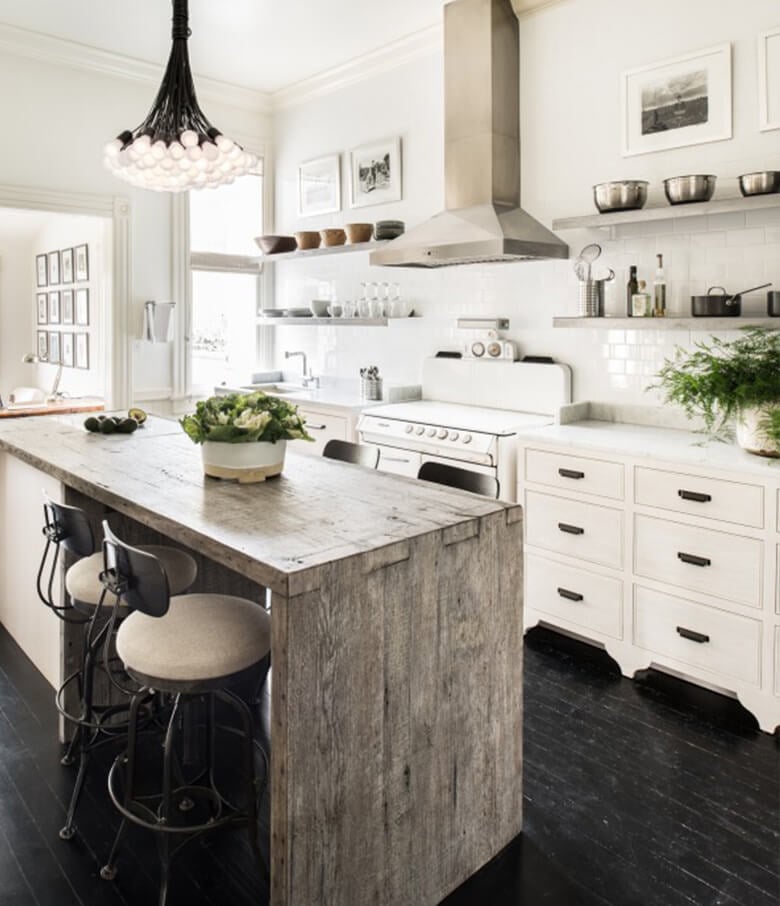Rustic kitchen with white inset cabinets and an oversized reclaimed wood island.